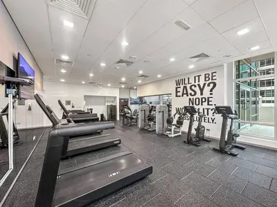 a gym with treadmills and machines in a room at FIRST CLASS 1BR Modern Downtown Oasis in Dubai