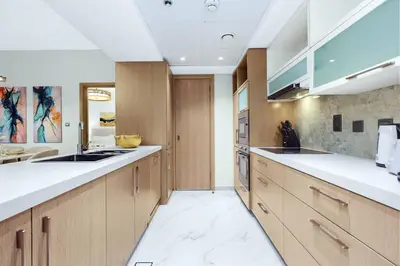 a large kitchen with wooden cabinets and white counter tops at FIRST CLASS 1BR Modern Downtown Oasis in Dubai