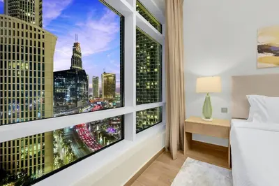 a bedroom with a large window with a view of the city at FIRST CLASS 1BR Modern Downtown Oasis in Dubai