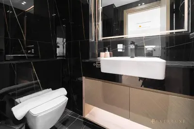 a bathroom with a white toilet and a sink at 1BR Gem in JVC Pool, Gym, BBQ & Balcony in Dubai