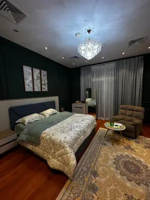 a bedroom with a large bed and a chandelier at Lavender 2 jvc in Dubai