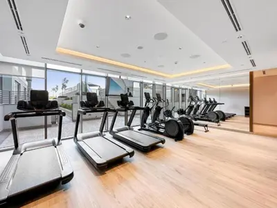 a gym with a row of treadms and elliptical machines at Locations I Creek Vistas Reserve I Luxury Calm 1BR I 12 Min Drive to Downtown Dubai & Business Bay I Modern Comfort in Meydan Community in Dubai