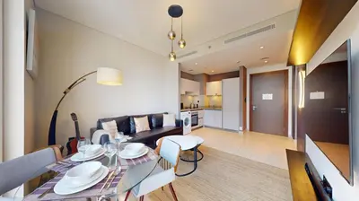 a living room with a table and a couch at Locations I Creek Vistas Reserve I Luxury Calm 1BR I 12 Min Drive to Downtown Dubai & Business Bay I Modern Comfort in Meydan Community in Dubai