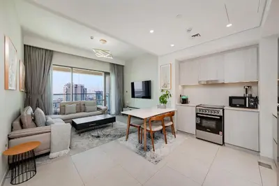 a kitchen and living room with a table and a couch at Vida Creek Beach 1 Bedroom in Dubai