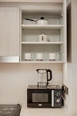 a kitchen with a blender on top of a microwave at Vida Creek Beach 1 Bedroom in Dubai