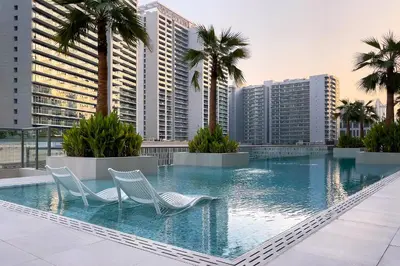 two chairs in a swimming pool with buildings at Studio Sterling BusinessBay in Dubai