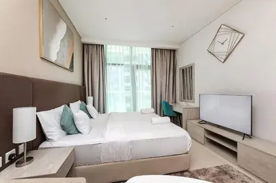 a bedroom with a bed and a flat screen tv at Modern Studio in Seven Palm in Dubai
