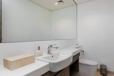 a white bathroom with a sink and a mirror at Burj Khalifa View 3bedroom in Dubai