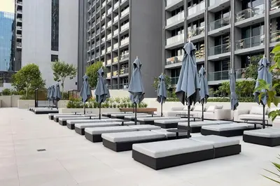 a row of tables with umbrellas in front of a building at Burj Khalifa View 3bedroom in Dubai