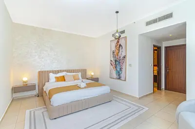 a bedroom with a large bed and a couch at Savis Homes - Luxury 2 Bedroom Suite with Full Burj Khalifa View in Dubai