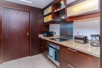 a kitchen with wooden cabinets and a counter top at Savis Homes - Luxury 2 Bedroom Suite with Full Burj Khalifa View in Dubai