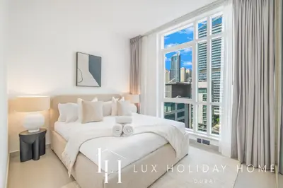 a bedroom with a bed and a large window at LUX The Majara Marina View Suite in Dubai