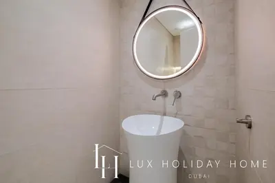 a bathroom with a round mirror and a sink at LUX The Majara Marina View Suite in Dubai