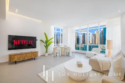 a living room with a tv and a couch at LUX The Majara Marina View Suite in Dubai
