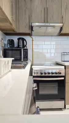 a kitchen with a stove and a microwave at Fully Furnished 1BR In Montrose Tower B Dubai, Close by Dubai Science Park, Dubai Miracle Garden, Dubai Hills Mall in Dubai
