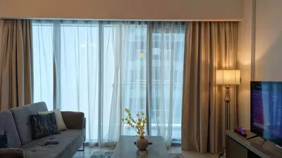 a living room with a couch and a large window at Fully Furnished 1BR In Montrose Tower B Dubai, Close by Dubai Science Park, Dubai Miracle Garden, Dubai Hills Mall in Dubai