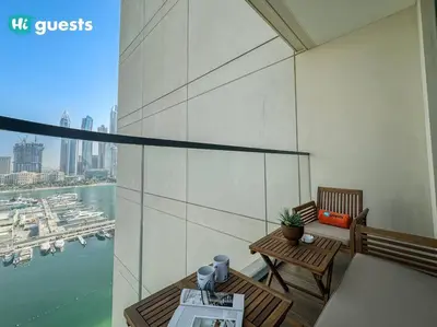 a balcony with a table and chairs and a view of a harbor at HiGuests - Elegant 2-Bedroom Retreat at Marina Vista 2 in Dubai