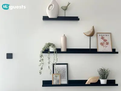 a wall with black shelves with plants and a vase at HiGuests - Elegant 2-Bedroom Retreat at Marina Vista 2 in Dubai