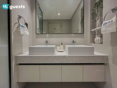 a bathroom with two sinks and a mirror at HiGuests - Elegant 2-Bedroom Retreat at Marina Vista 2 in Dubai