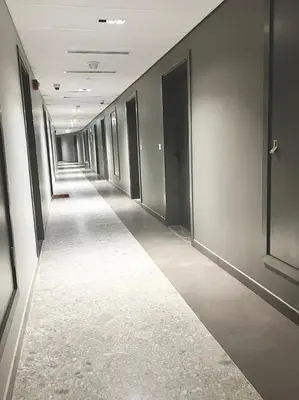 a hallway of an office building with a row of doors at Elegant Studio Stay near Miracle Garden, Butterfly Garden & Dubai Hills Mall in Dubai