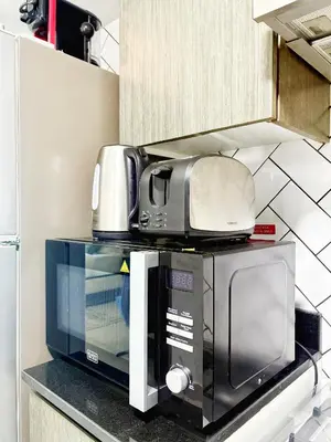 a microwave sitting on top of a kitchen counter at Elegant Studio Stay near Miracle Garden, Butterfly Garden & Dubai Hills Mall in Dubai