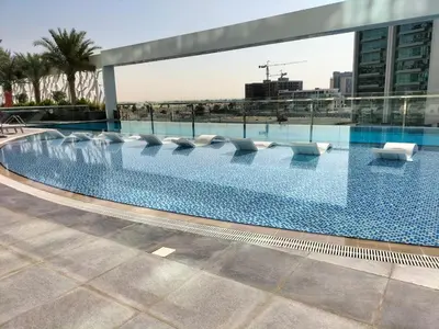 a swimming pool on the roof of a building at Elegant Studio Stay near Miracle Garden, Butterfly Garden & Dubai Hills Mall in Dubai