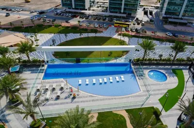 an overhead view of a resort with a swimming pool at Elegant Studio Stay near Miracle Garden, Butterfly Garden & Dubai Hills Mall in Dubai