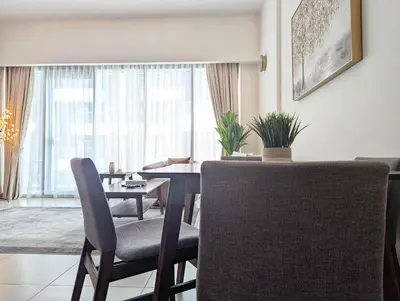 a living room with a dining room table and chairs at Fully Furnished 1BR Close by Dubai Science Park, Dubai Miracle Garden, Dubai Hills Mall in Dubai