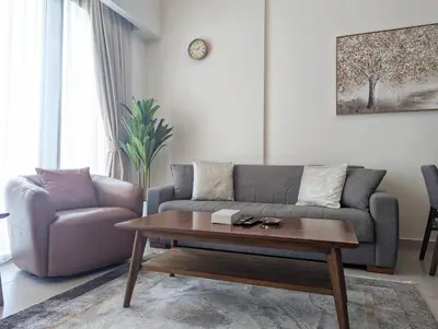 a living room with a couch and a coffee table at Fully Furnished 1BR Close by Dubai Science Park, Dubai Miracle Garden, Dubai Hills Mall in Dubai