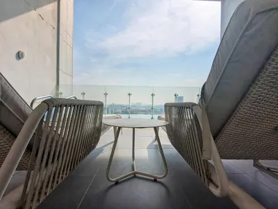 a table and chairs on a balcony with a view at Fully Furnished 1BR Close by Dubai Science Park, Dubai Miracle Garden, Dubai Hills Mall in Dubai