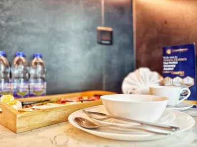 a table with plates and cups and a tray of food at Fully Furnished Cozy Studio Studio Apartment in JVC Dubai in Dubai