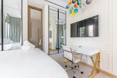 a bedroom with a bed and a desk and a tv at Ultra-Luxury 6BR Palm Villa - Private Pool & Beach in Dubai