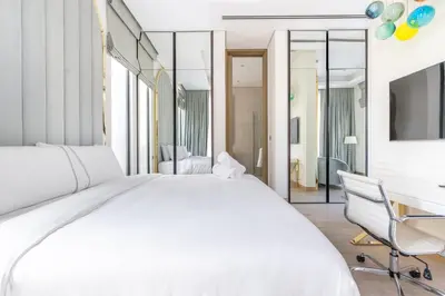 a white bedroom with a large bed and a desk at Ultra-Luxury 6BR Palm Villa - Private Pool & Beach in Dubai