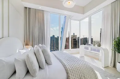 a bedroom with a white bed with a large window at Daniels Stylish 1BR at Silverene Tower Dubai Marina in Dubai