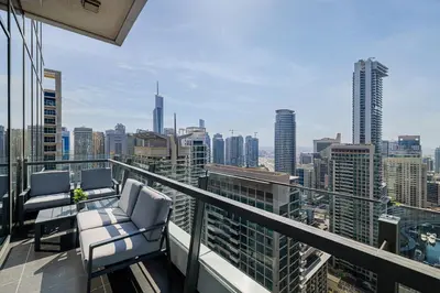 a balcony with chairs and a view of the city at Daniels Stylish 1BR at Silverene Tower Dubai Marina in Dubai