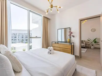a bedroom with a white bed and a large window at Modern Spacious- 2 BR with Pool & Gym- Luma 22 JVC in Dubai