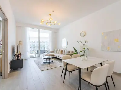 a living room with a table and a couch at Modern Spacious- 2 BR with Pool & Gym- Luma 22 JVC in Dubai