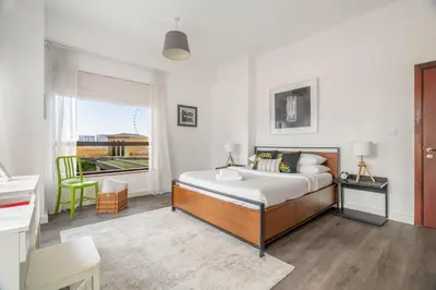 a white bedroom with a bed and a window at GuestReady - Serene retreat with Ain Dubai Views in Dubai