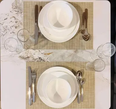 a table with two plates and two wine glasses at Airvistas CityNest Retreat at Business Bay, Dubai in Dubai