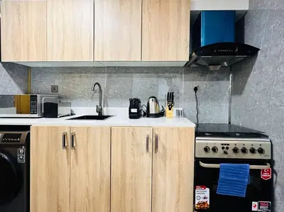 a kitchen with wooden cabinets and a sink and a stove at Airvistas CityNest Retreat at Business Bay, Dubai in Dubai