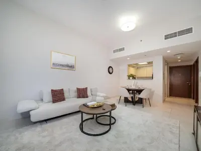 a living room with a white couch and a table at Chic 1 Bed Getaway in Al Jaddaf Easy City Access in Dubai