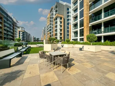 a patio with a table and chairs and buildings at Elegant Studio in Azizi Riviera, Meydan in Dubai