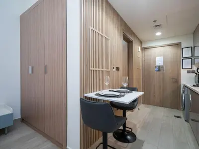 a kitchen with a table and chairs in a room at Elegant Studio in Azizi Riviera, Meydan in Dubai