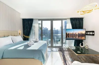 a bedroom with a bed and a tv on a wall at Lux apartments x Dubai studio 22 in Dubai