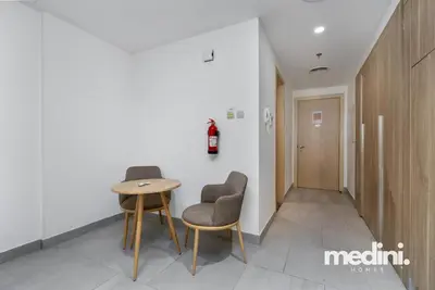 a hallway with two chairs and a table in a room at Large studio in JVC - Dubai in Dubai