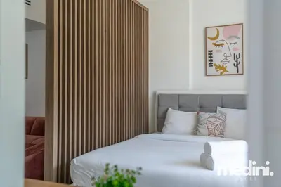 a bedroom with a bed with a wooden headboard at Large studio in JVC - Dubai in Dubai