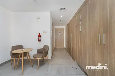 a hallway with two chairs and a table in a room at Large studio in JVC - Dubai in Dubai
