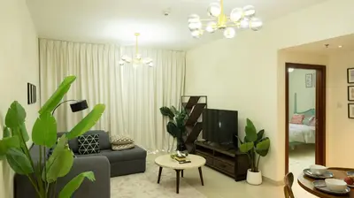 a living room with a couch and a tv at Modern Apartment near Burj khalifa in Dubai