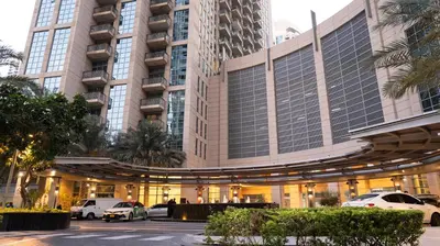 a large building with cars parked in front of it at Modern Apartment near Burj khalifa in Dubai