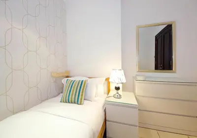 a small bedroom with a bed and a mirror at Elegant 2BR Apartment in Yansoon 3 with Burj Khalifa Views in Dubai